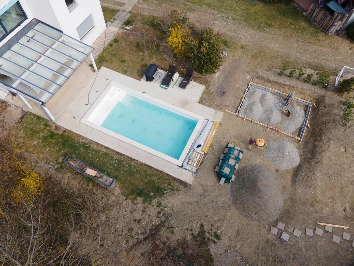 Drone shot of pool construction site with sheeting and gravel for a concrete pad for pool house in march