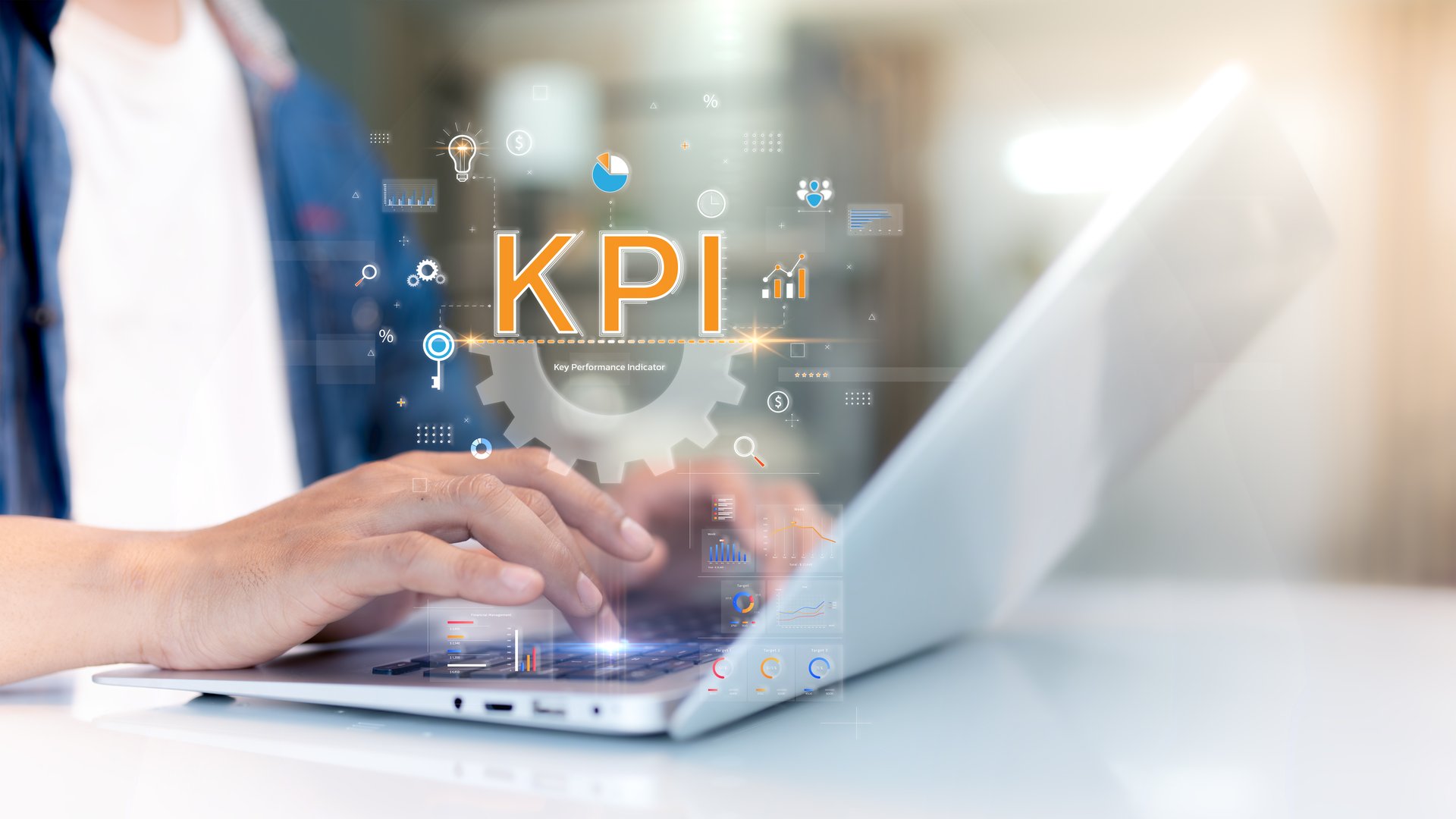 A person typing on a laptop with "KPI" and various digital icons representing data, analytics, and performance metrics displayed in a futuristic interface.