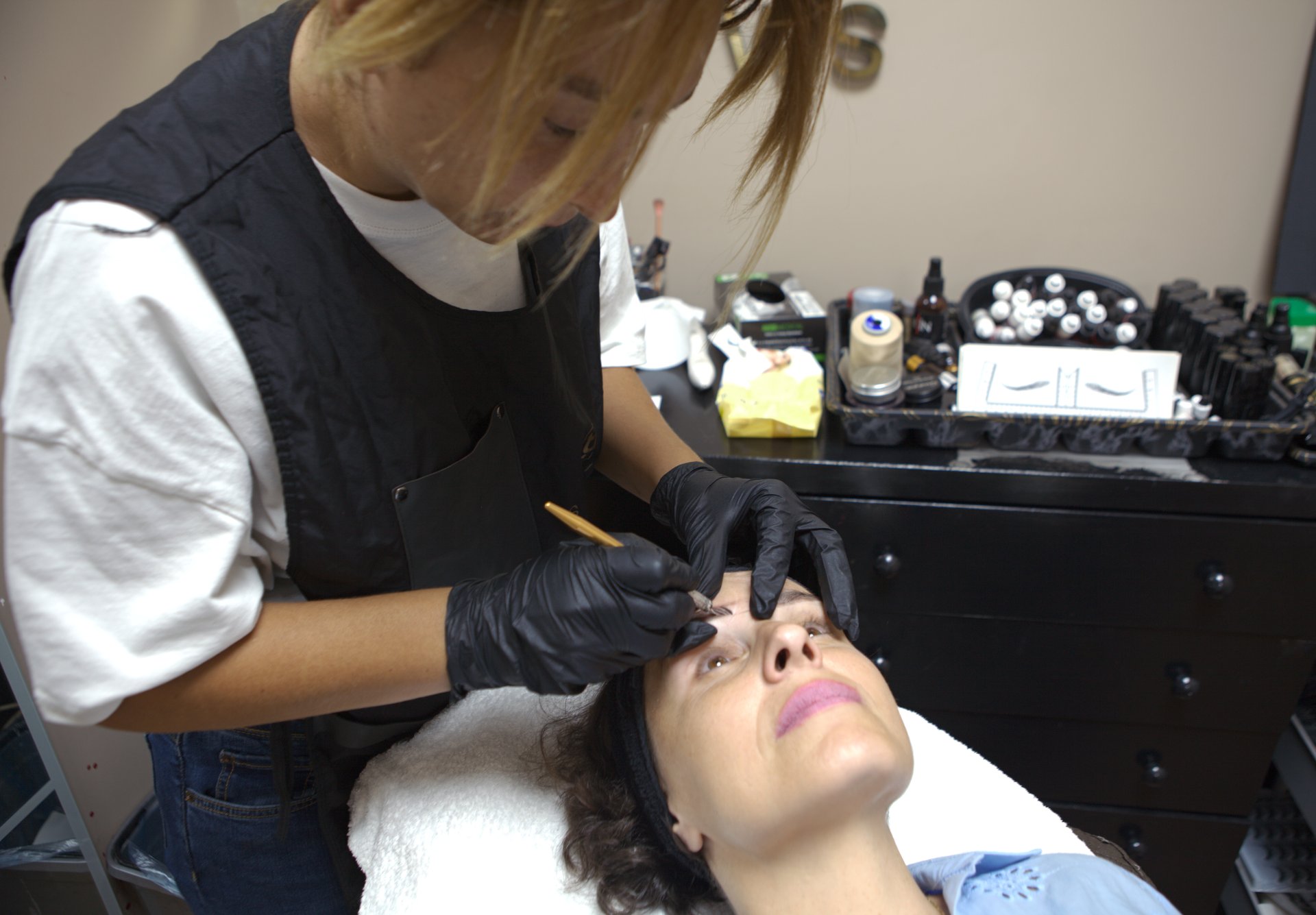 Young woman undergoing microblading operation in the beauty salon.
