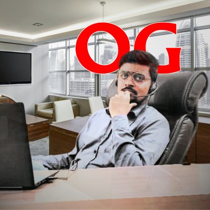 Person with a headset sitting at a desk in an office with large windows, a laptop, and "OG" in red text above them.