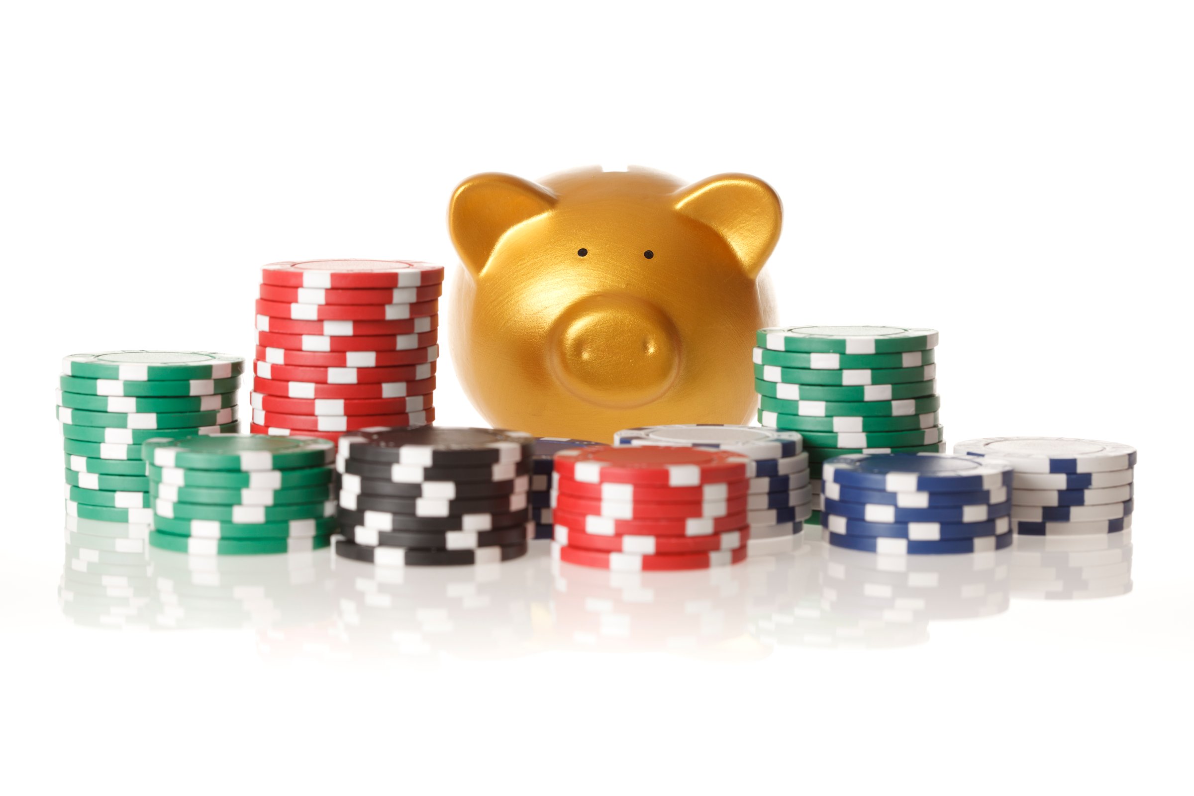 Golden piggy bank gambling with gambling chips. Ideal image for risk with savings themes. This is an exclusive image and it can only be found in iStockphoto.
