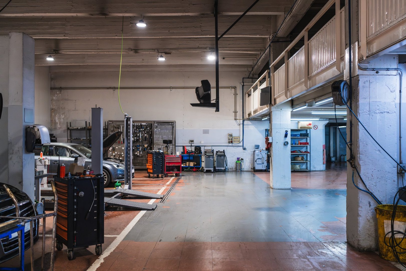 Wide shot of a car repair shop with lifts and toolboxes, ready for mechanics to start working
