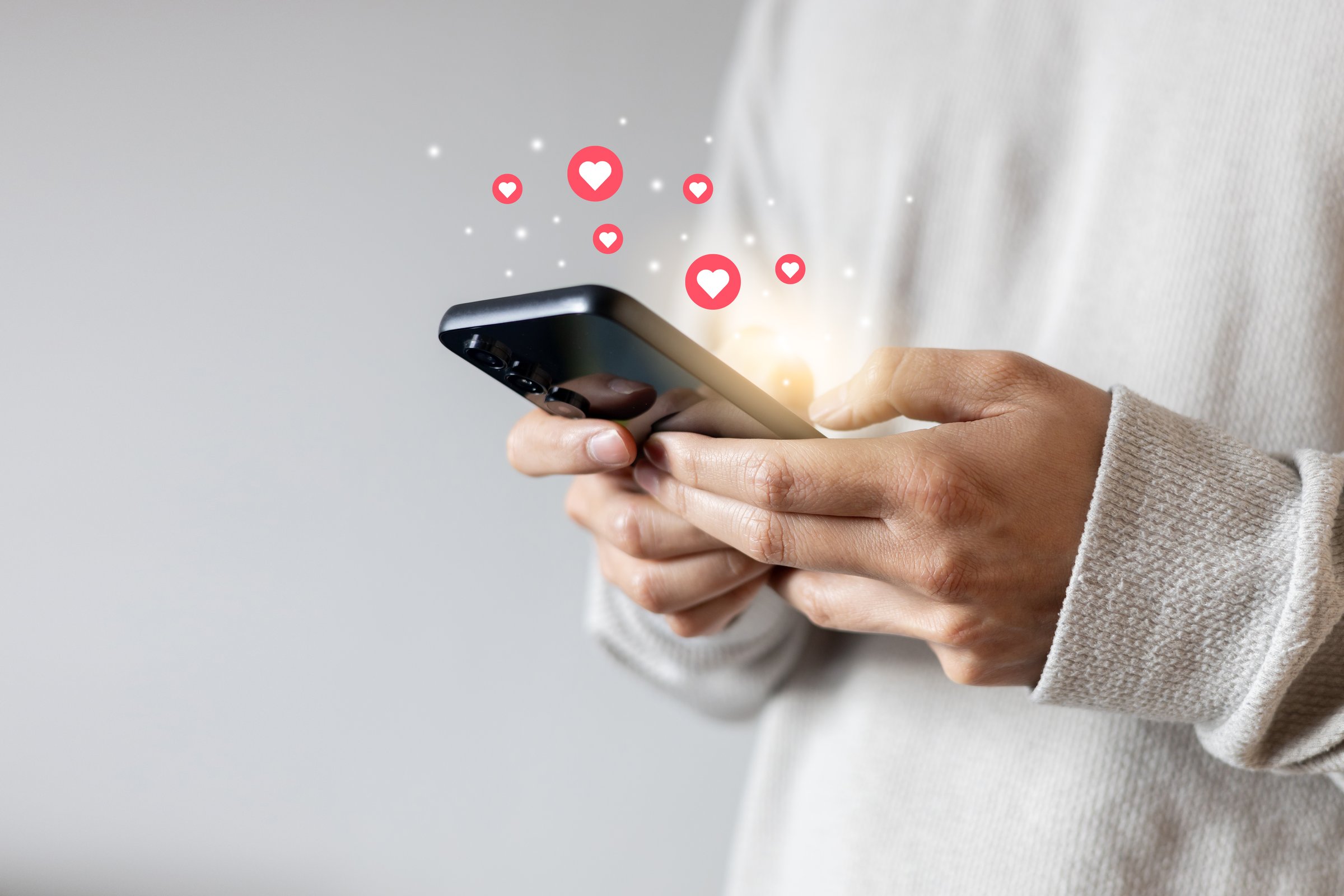 close up young woman hand hold and using smartphone to surf on social media platform and give a heart and love symbol to trendy or popular image or satisfy content for people and lifestyle concept