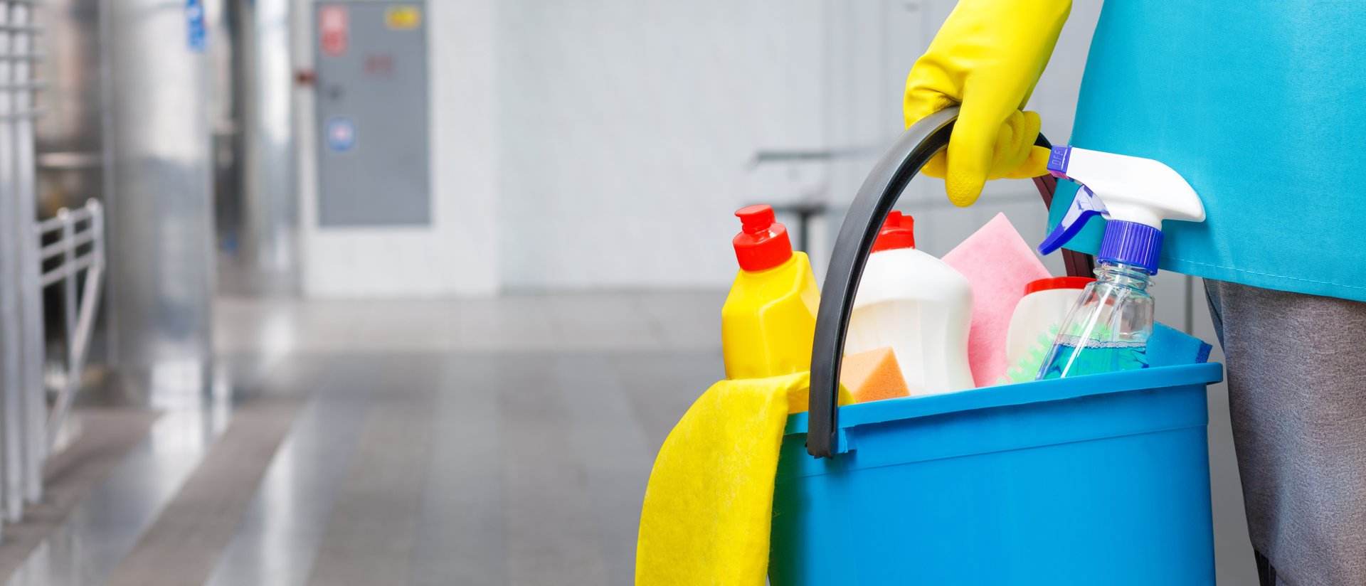 Cleaning woman with cleaning products in a bucket against the backdrop of the cleaned floor.