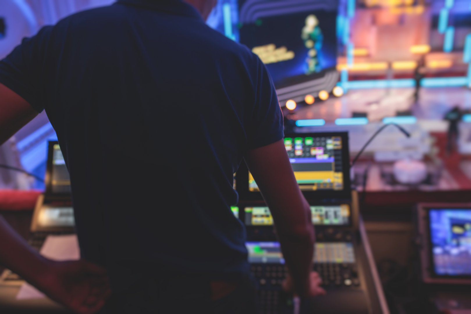 View of a lighting technician operator working on mixing console workplace during live event concert on stage show broadcast, light mixer controller panel, sound technician with professional equipment