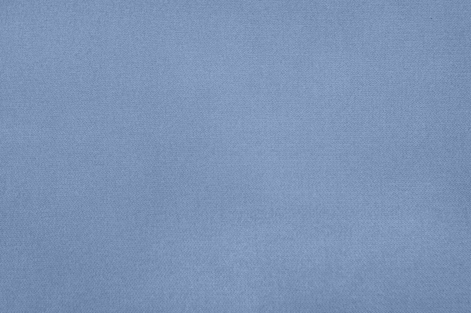 A close-up view captures the intricate texture of a blue fabric, showing a detailed weave pattern. The image conveys a sense of softness.