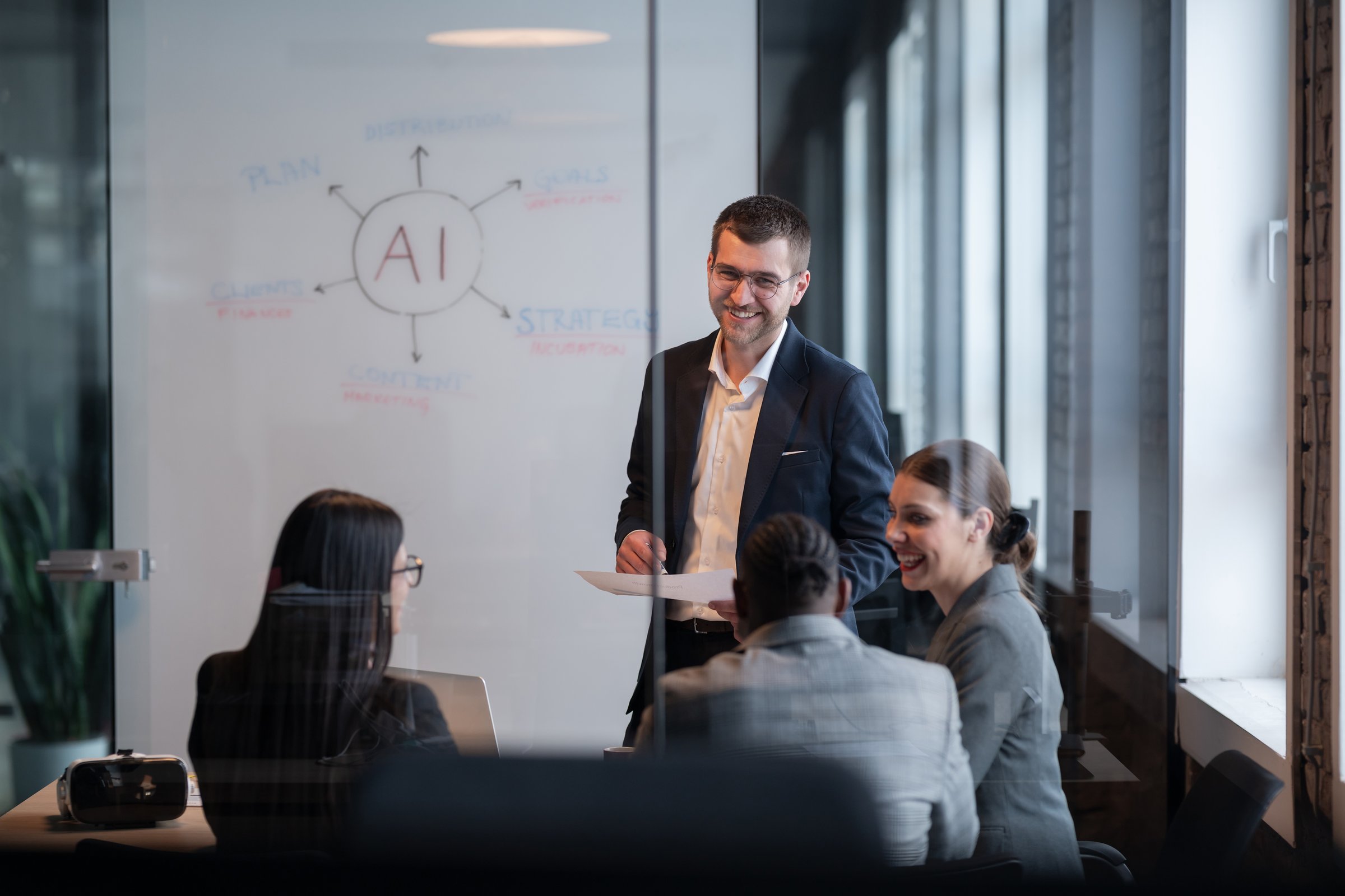 Diverse business team in a modern office during a meeting, discussing artificial intelligence strategy. Concept of AI innovation, teamwork, leadership, corporate planning, professional collaboration.