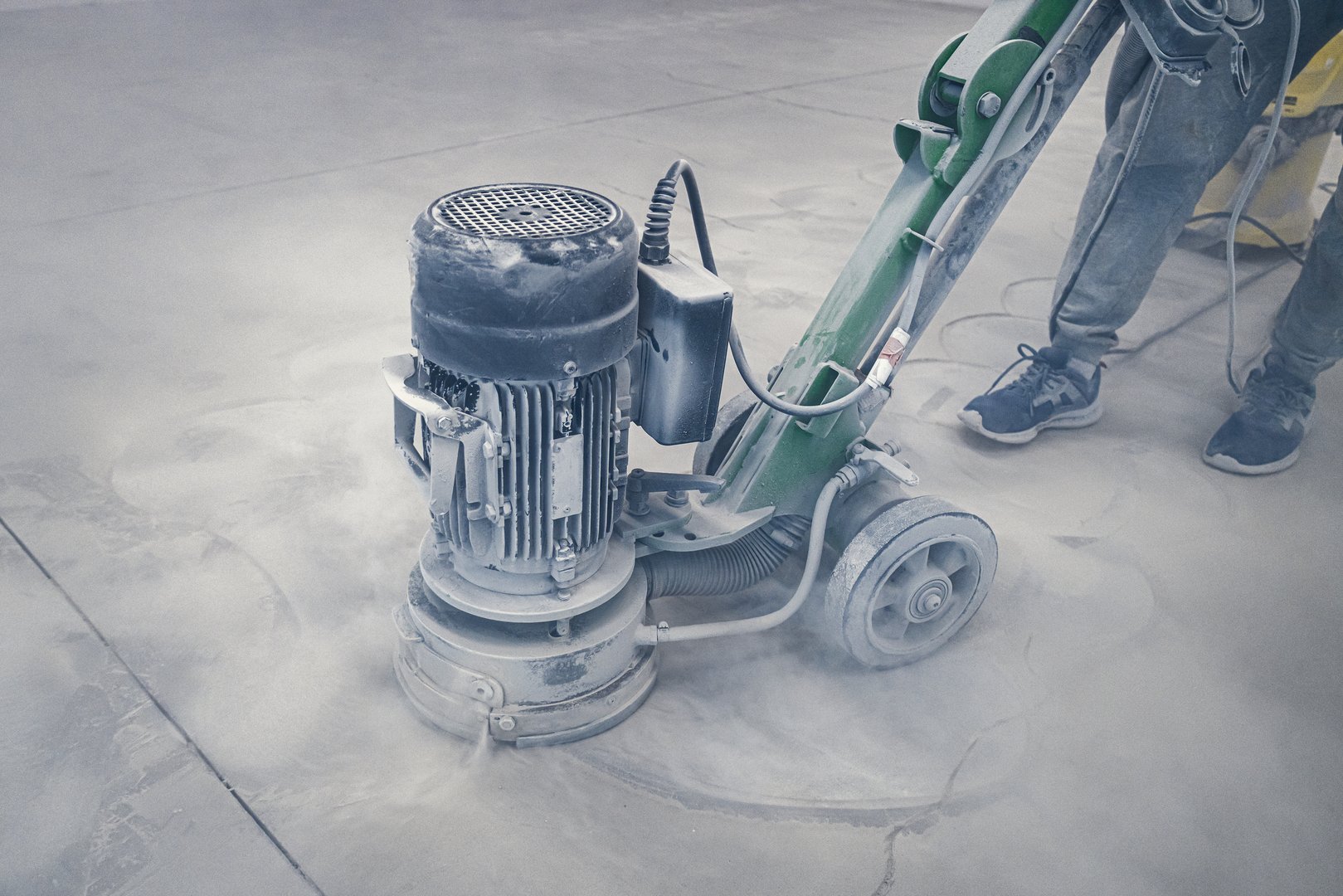 Sanding a concrete floor before painting with epoxy industrial paints