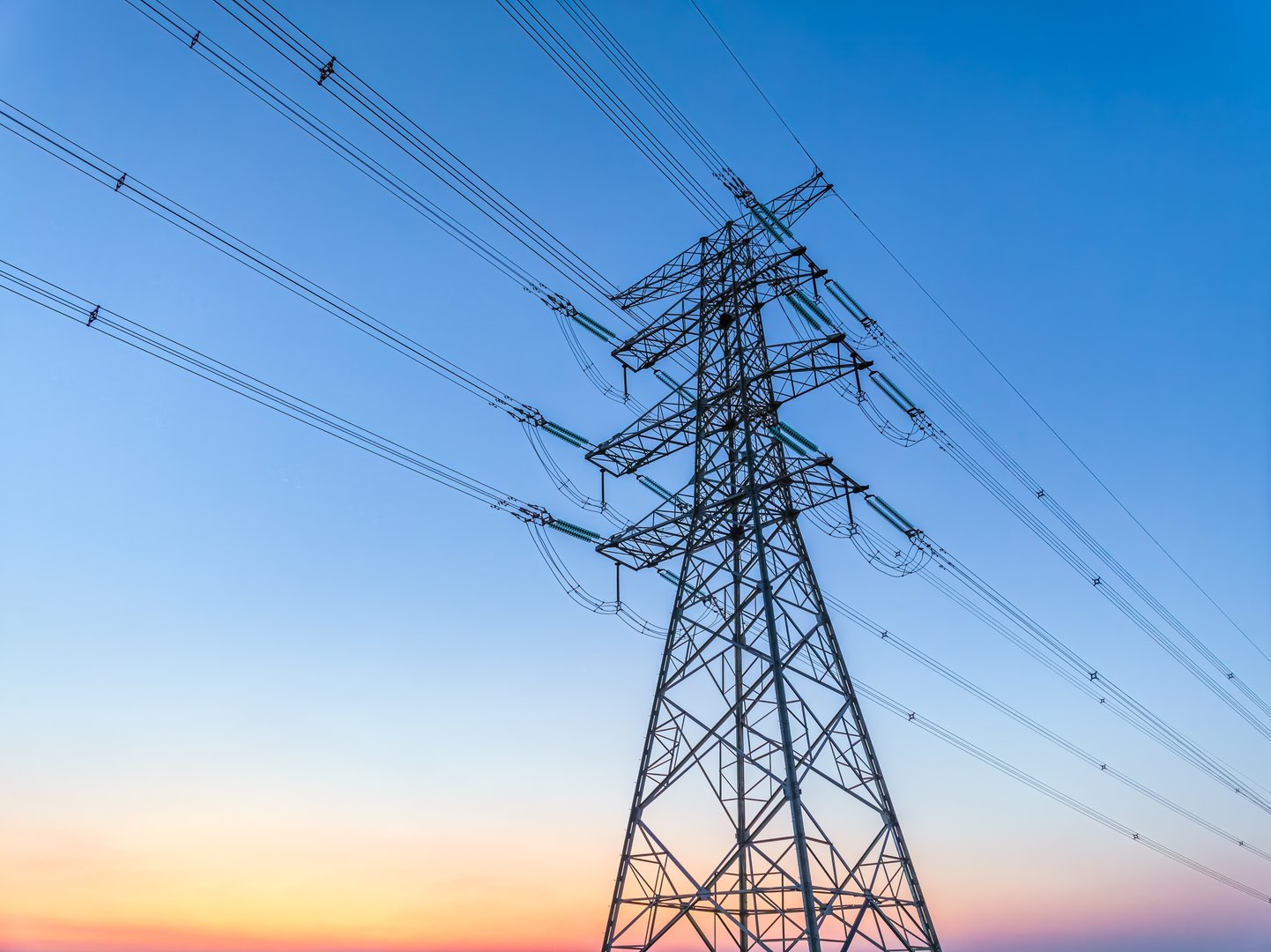High voltage electricity tower and natural scenery at sunset in summer