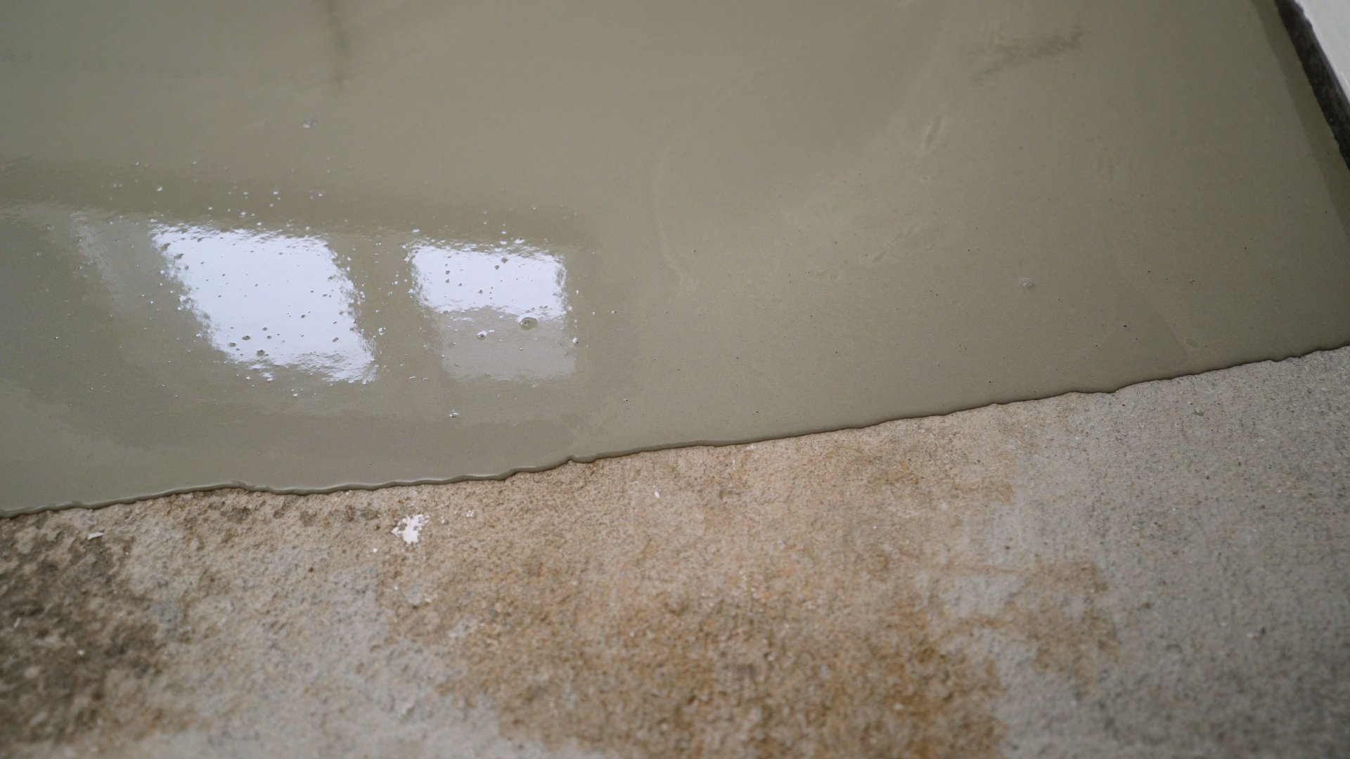 Applying epoxy resin on a concrete surface, creating a smooth and durable finish ideal for industrial and commercial settings