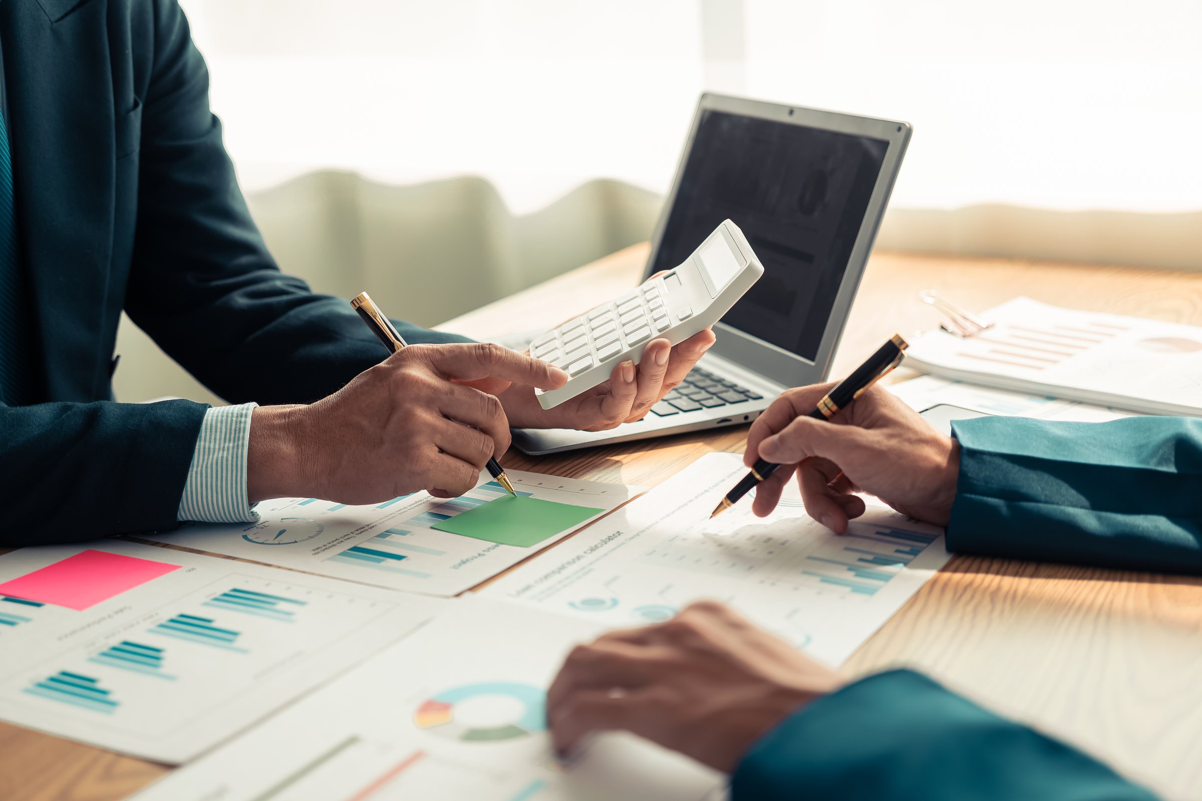 Business people discussing charts and graphs showing results of teamwork in a meeting to analyze financial reports, planning strategies, success.