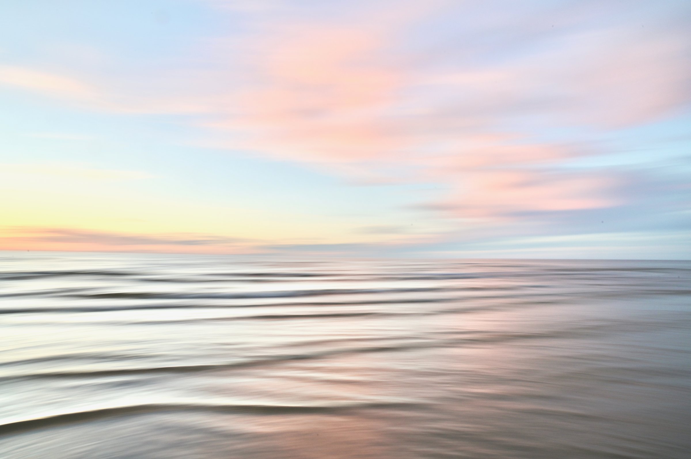 A tranquil seascape where the horizon gently blends the sky and sea