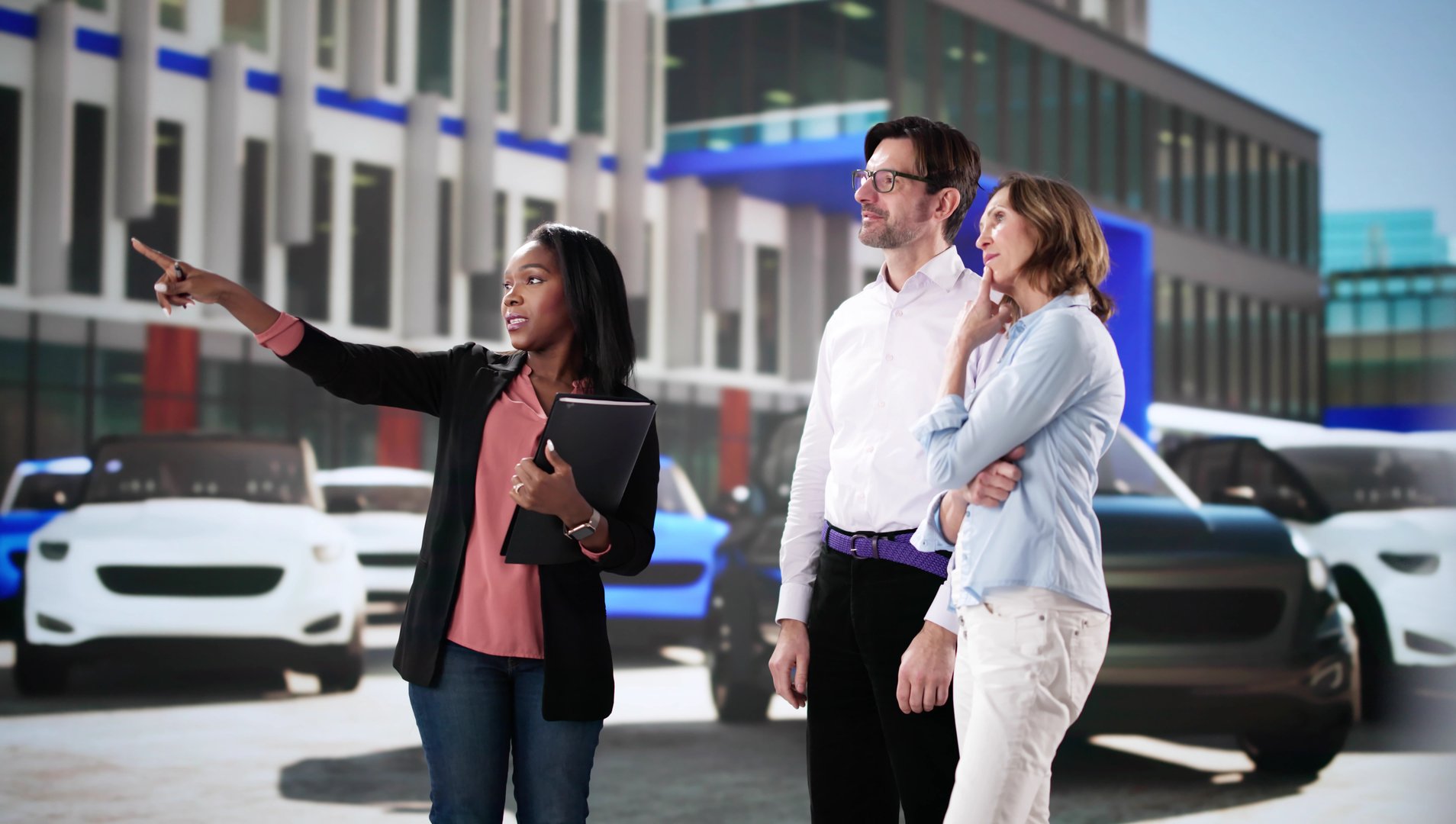 Couple negotiating contract with dealership for new car purchase.