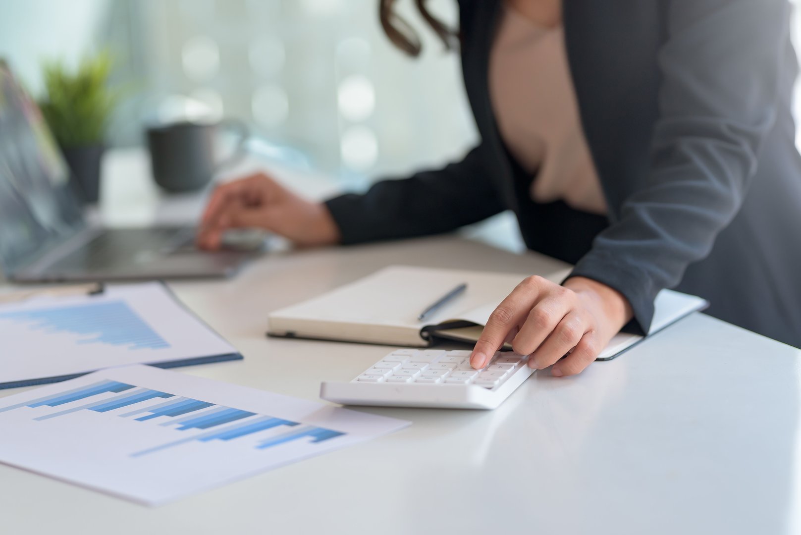 Businesswoman sitting planning analyze investment and marketing on the desk in the office.
