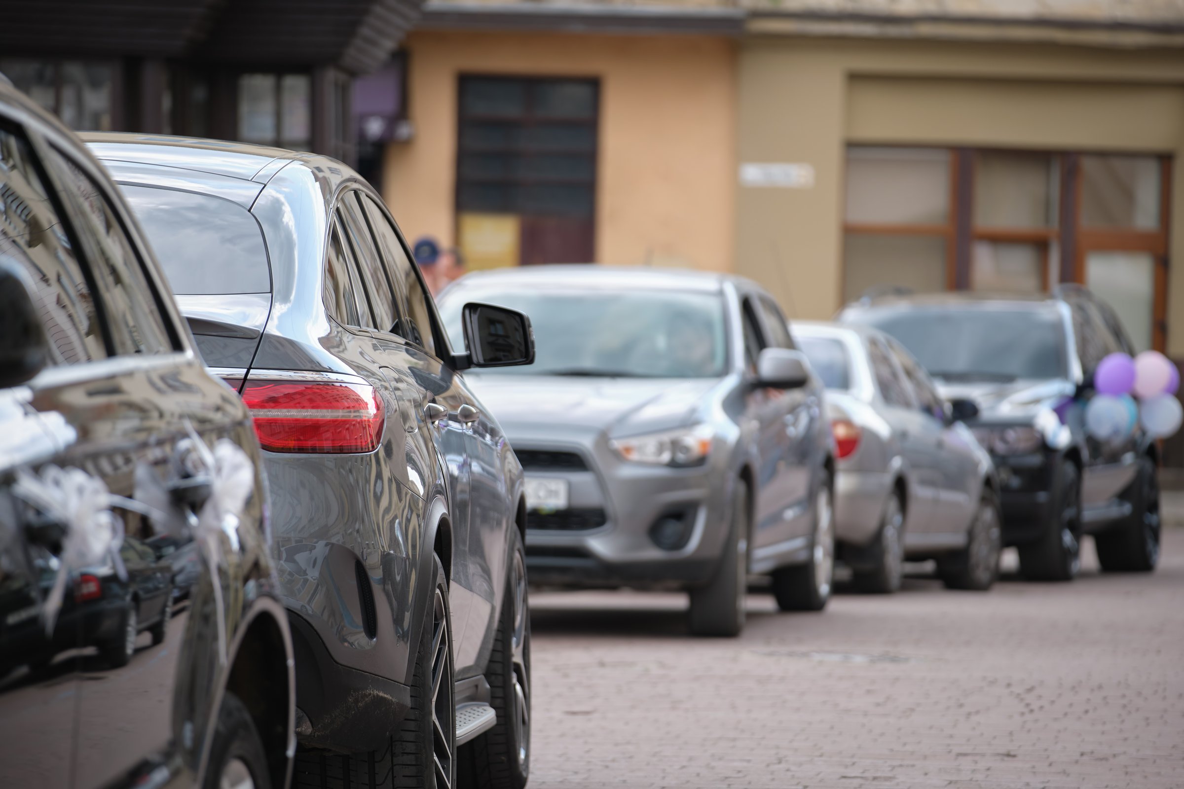 Cars parked in line on city street side. Urban traffic concept.