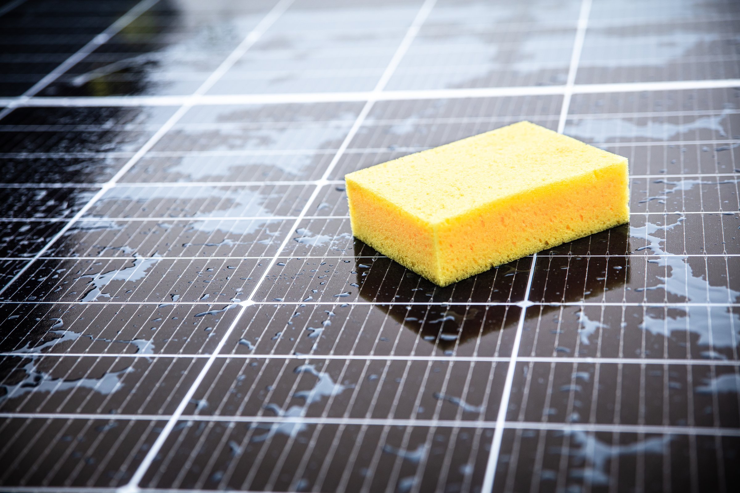 close-up of cleaning a pv panel with a sponge, maintenance of a photovoltaic system