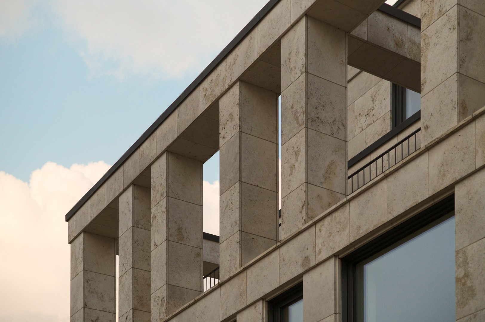 Architectural detail of a contemporary building showcasing travertine cladding and minimalist design