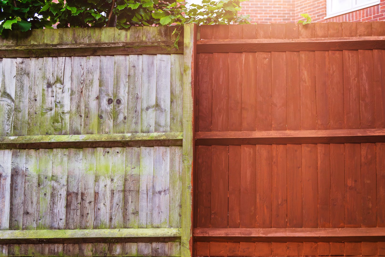 Painting old wooden fence with a brown paint, renovation concept. Before and After image