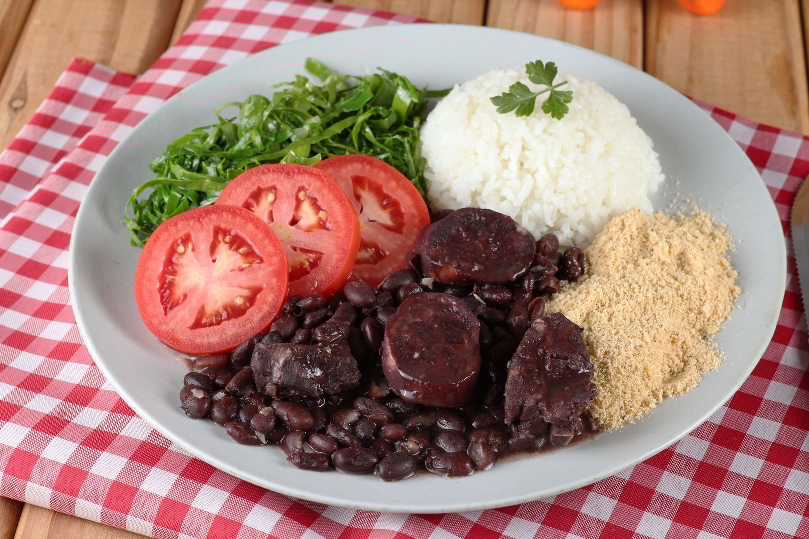 feijoada on a plate with rice, farofa and kale