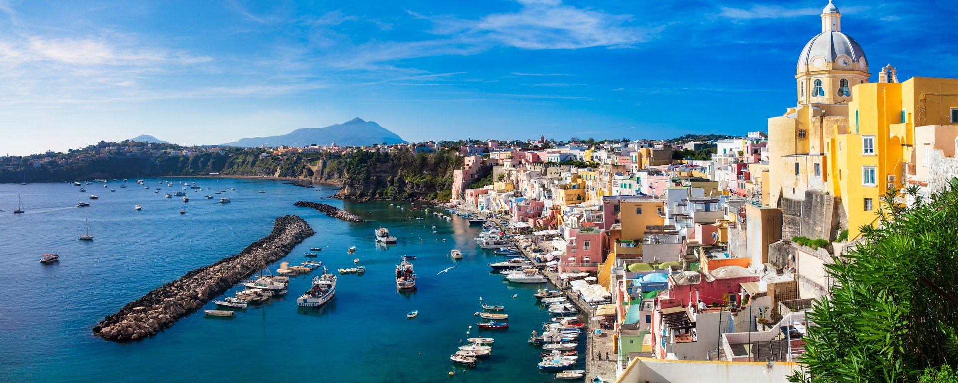 Italy travel and landmarks. Most scenic and colorful island - beautiful Procida in gulf of Naples. Port of Corricella panoramic view with yellow church