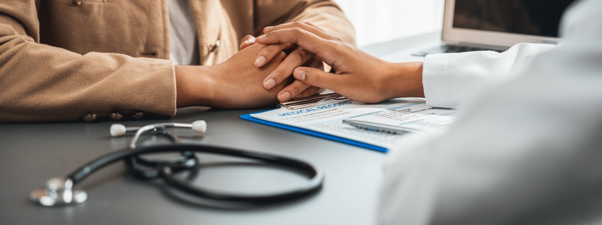 Doctor show medical diagnosis report and providing compassionate healthcare consultation while holding young patient hand for being supportive and professional in doctor clinic office. Neoteric