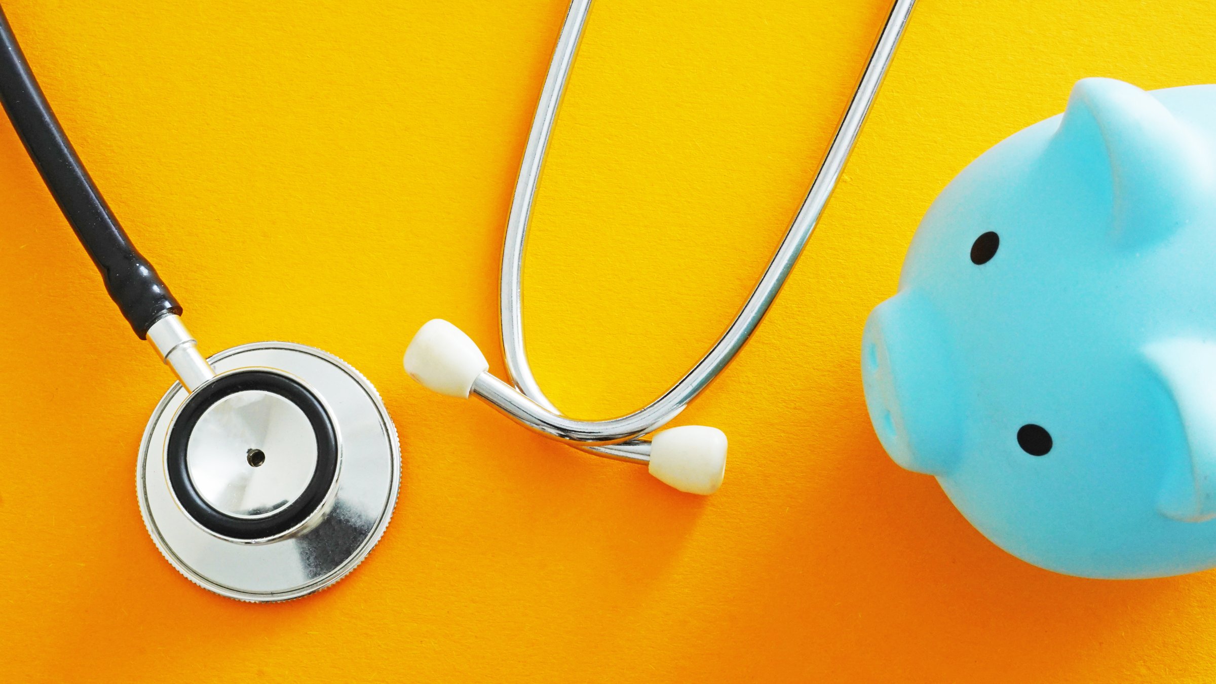 Stethoscope and piggy bank. Represents healthcare costs and medical savings.