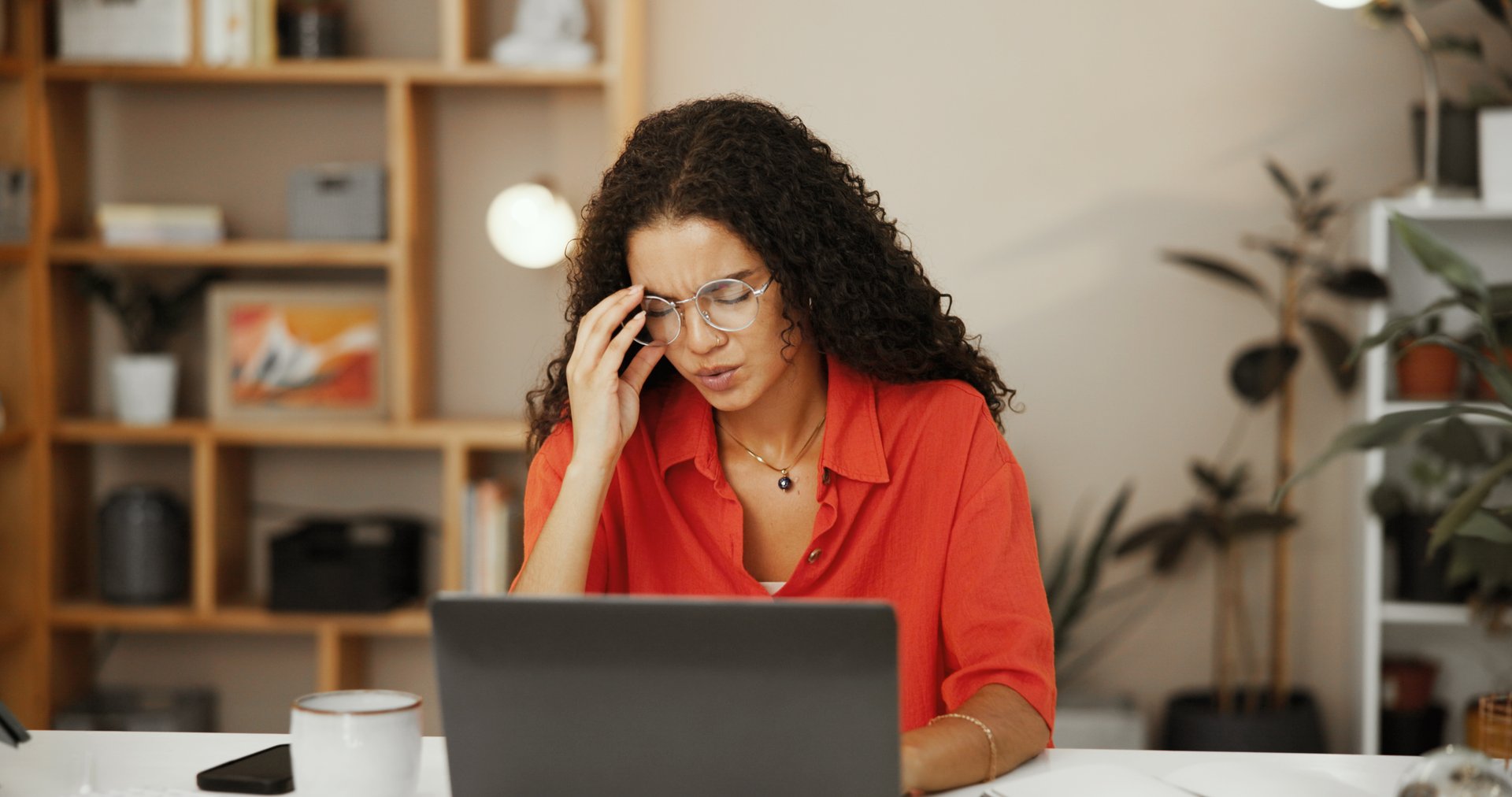 Frustrated, laptop and woman with headache, office and stress for tax filing on web or small business. Burnout, contemplating and person with migraine for online shop, entrepreneur and overwhelmed