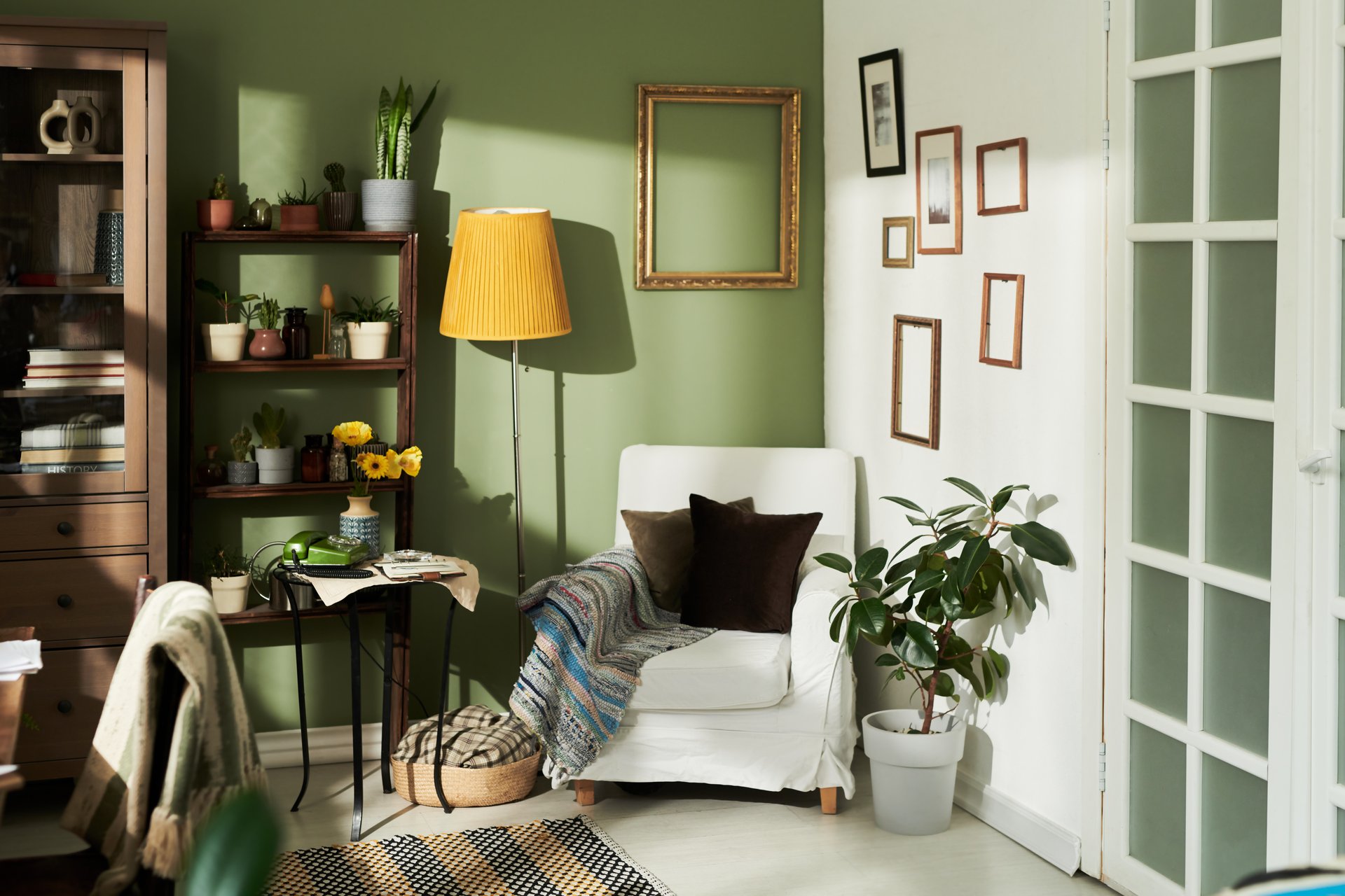 Sunlit corner of modern home featuring a cozy armchair with plants, decorative frames and a stylish lamp showing a blend of functionality and aesthetics