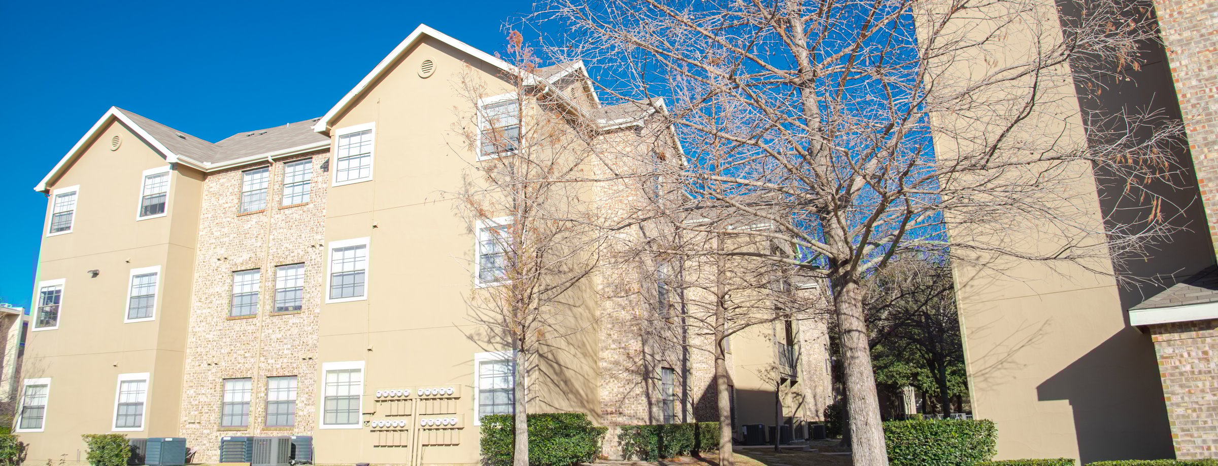 Panorama view AC units and electric meter panels outside of student housing multistory college apartment sunny winter blue sky in Dallas, on-campus housing dormitory residence hall education. Texas