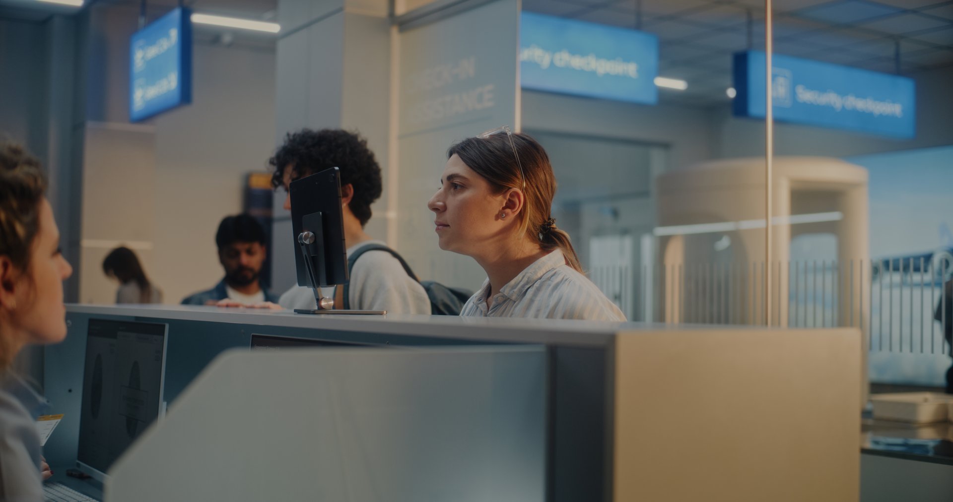 Airport Check-in Counter: Woman Giving Passport and Airplane Ticket to Female Airline Agent, Verifying Biometric Data by Facial Recognition Scanning. Documents Check in International Airport Terminal.