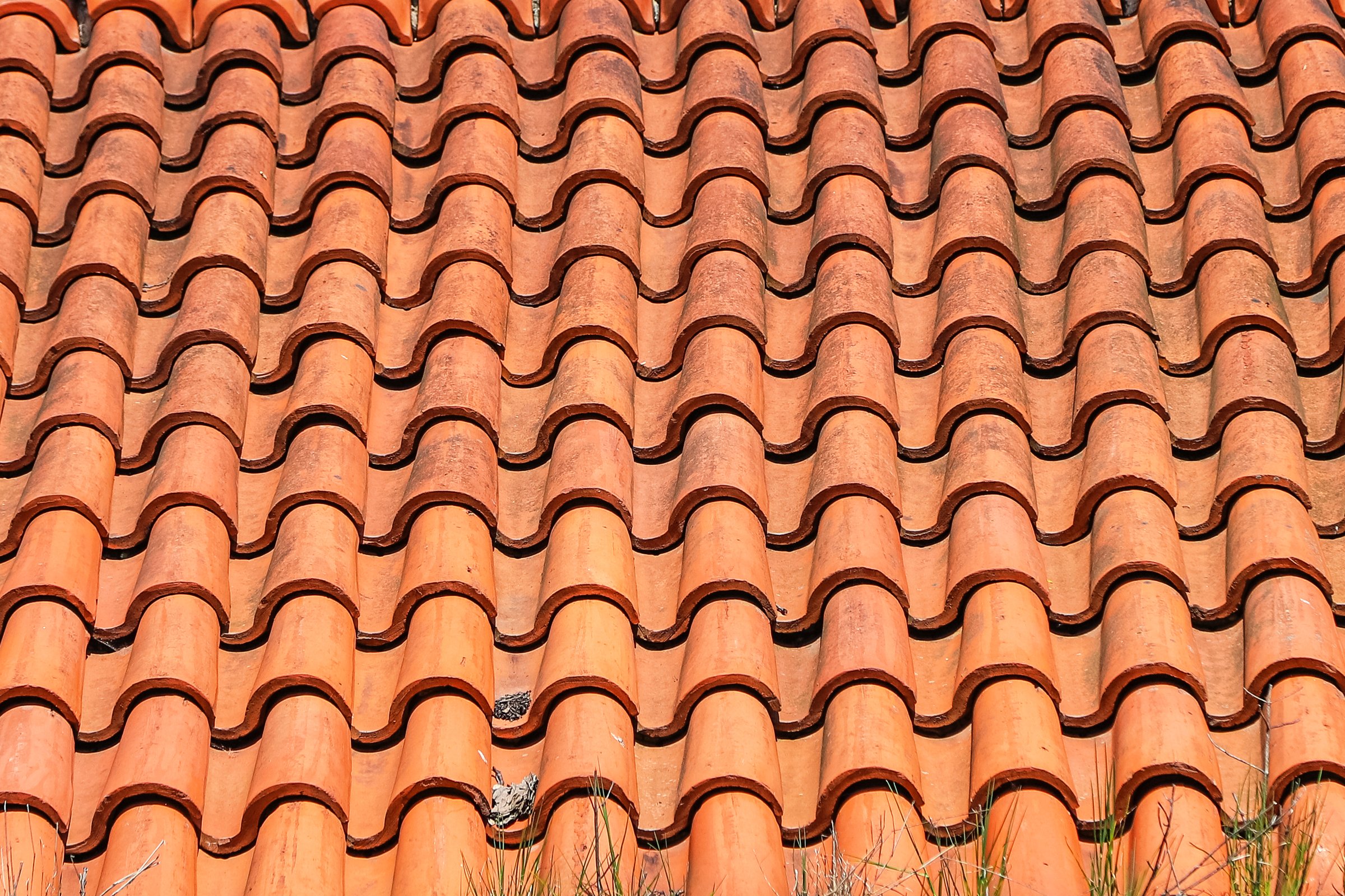 Closeup of an old roof tiled with S-shaped clay tiles. Photo in perspective with selective focus