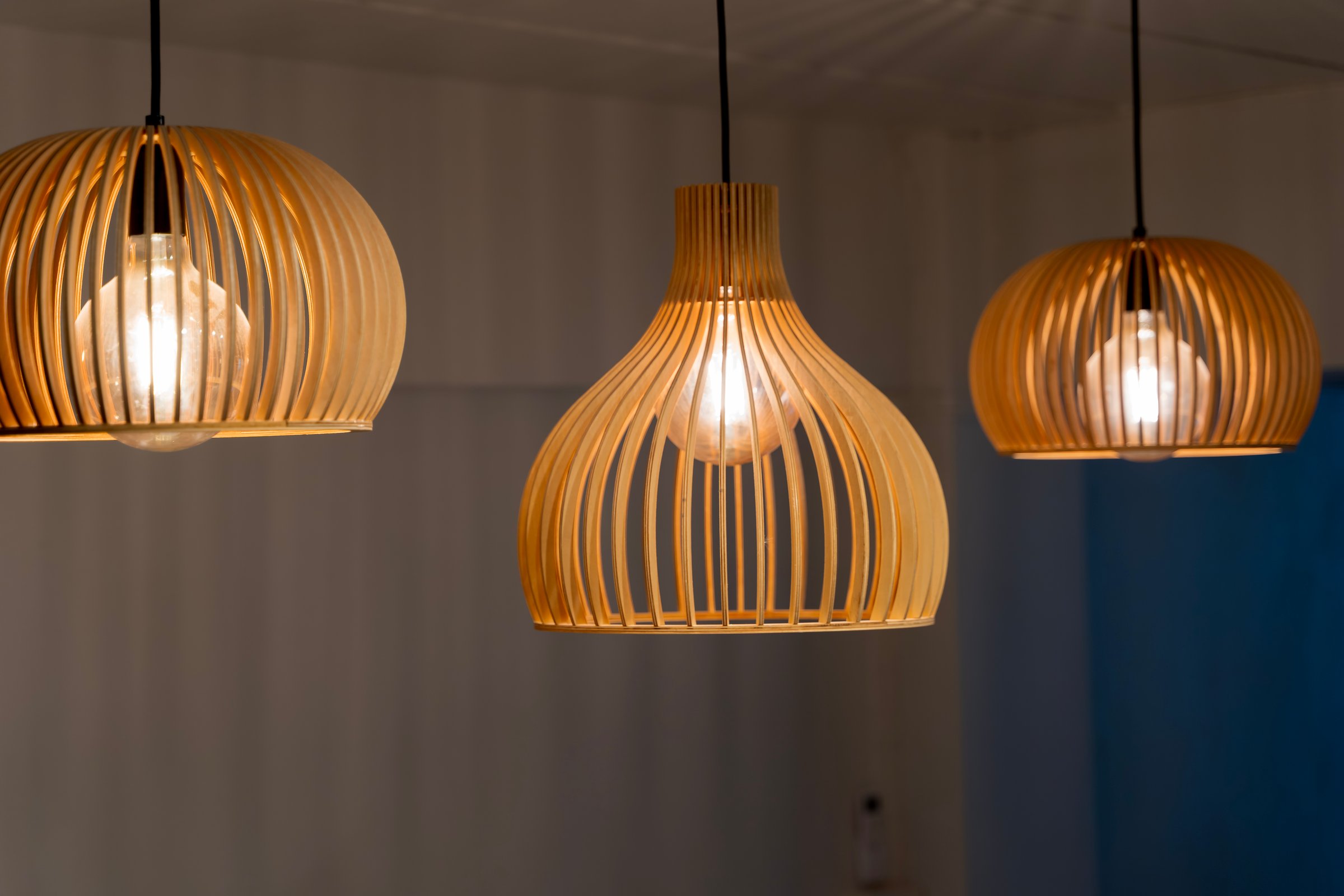 Close up of modern wooden pendant ceiling lamps with glowing bulbs. Interior decoration concept for home, or restaurant.
