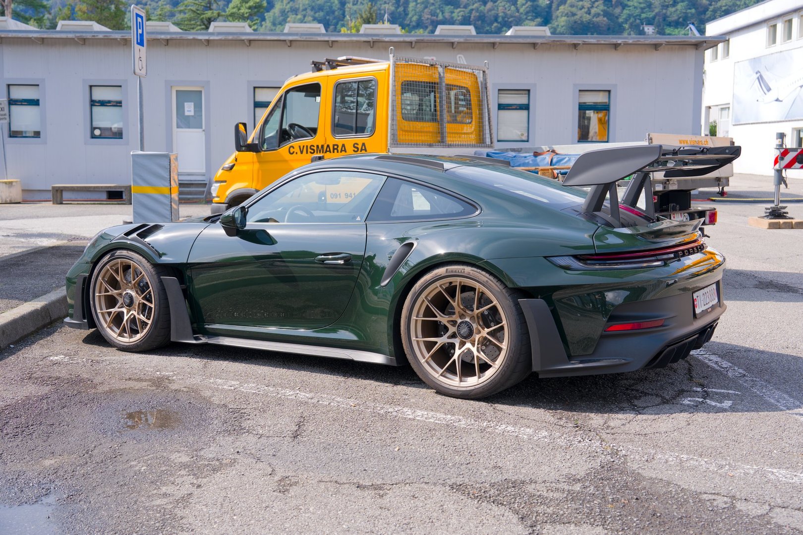 Green and gold colored parked Porsche 992 GT3 RS MkI sports car at parking of Lugano Airport on a sunny late summer day. Photo taken September 12th, 2025, Agno, Switzerland.