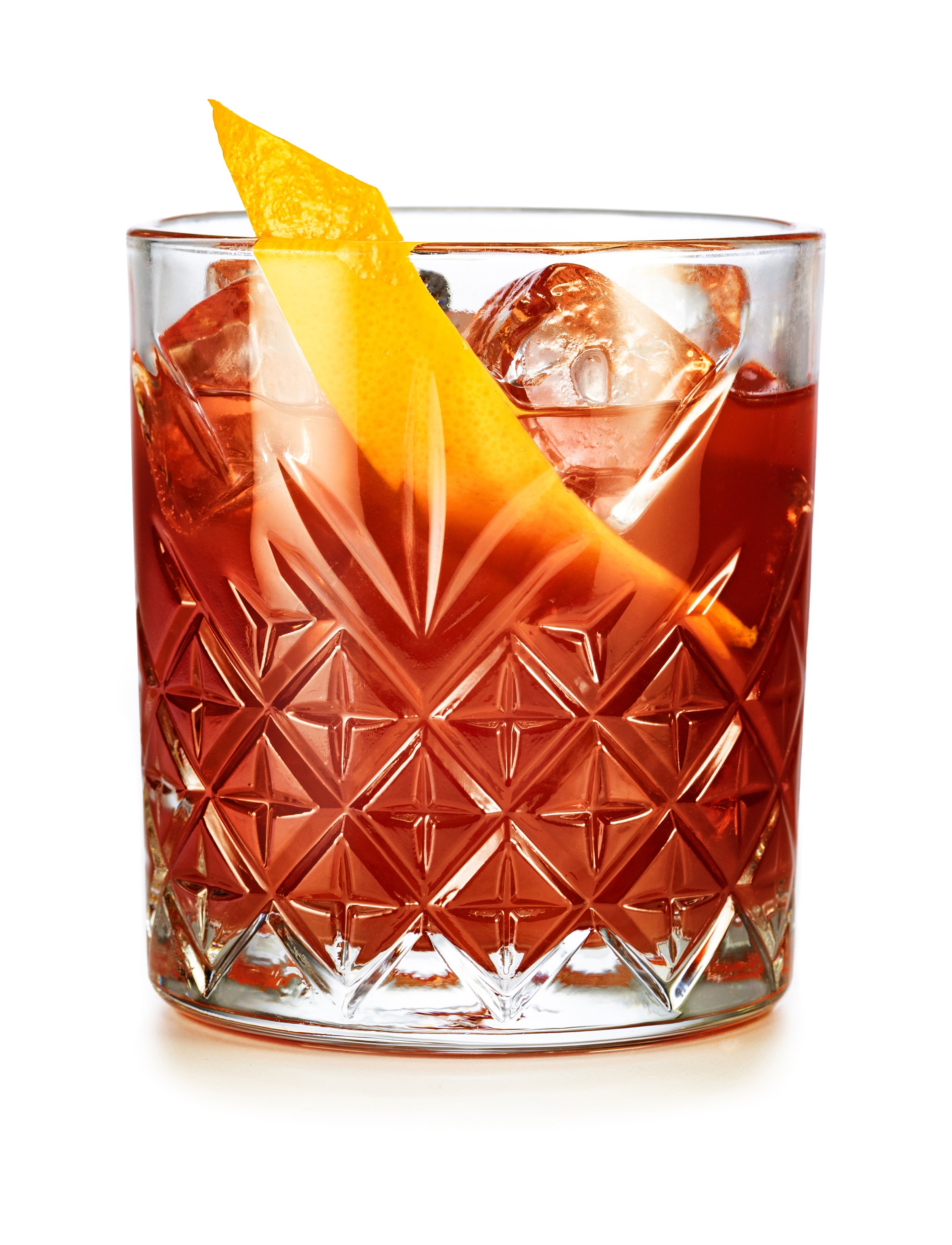 Classic Negroni cocktail garnished with orange peel isolated on white background.
