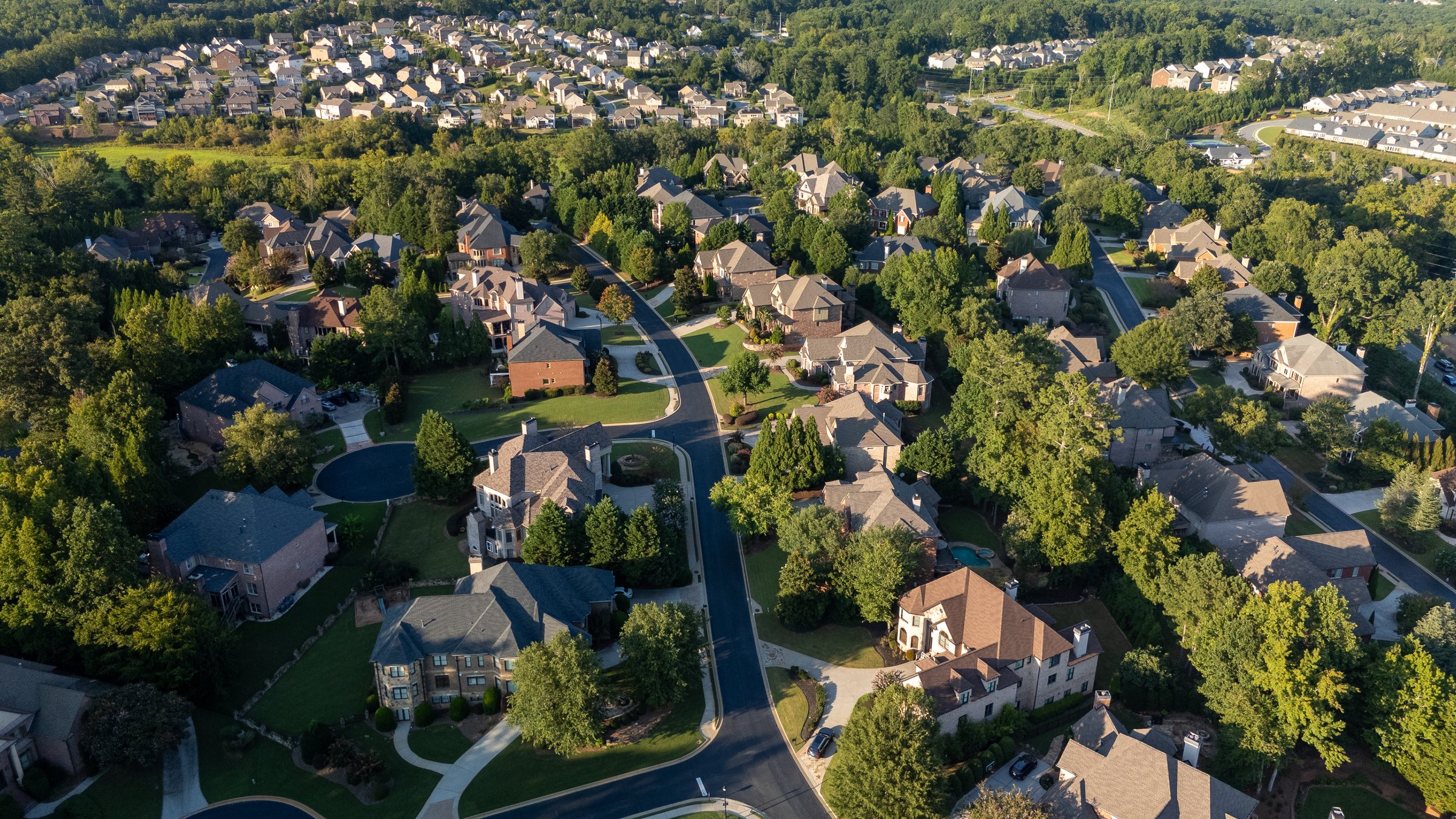 Aerial view of an upscale subdivision with beautiful houses in suburbs of USA shot during golden hour