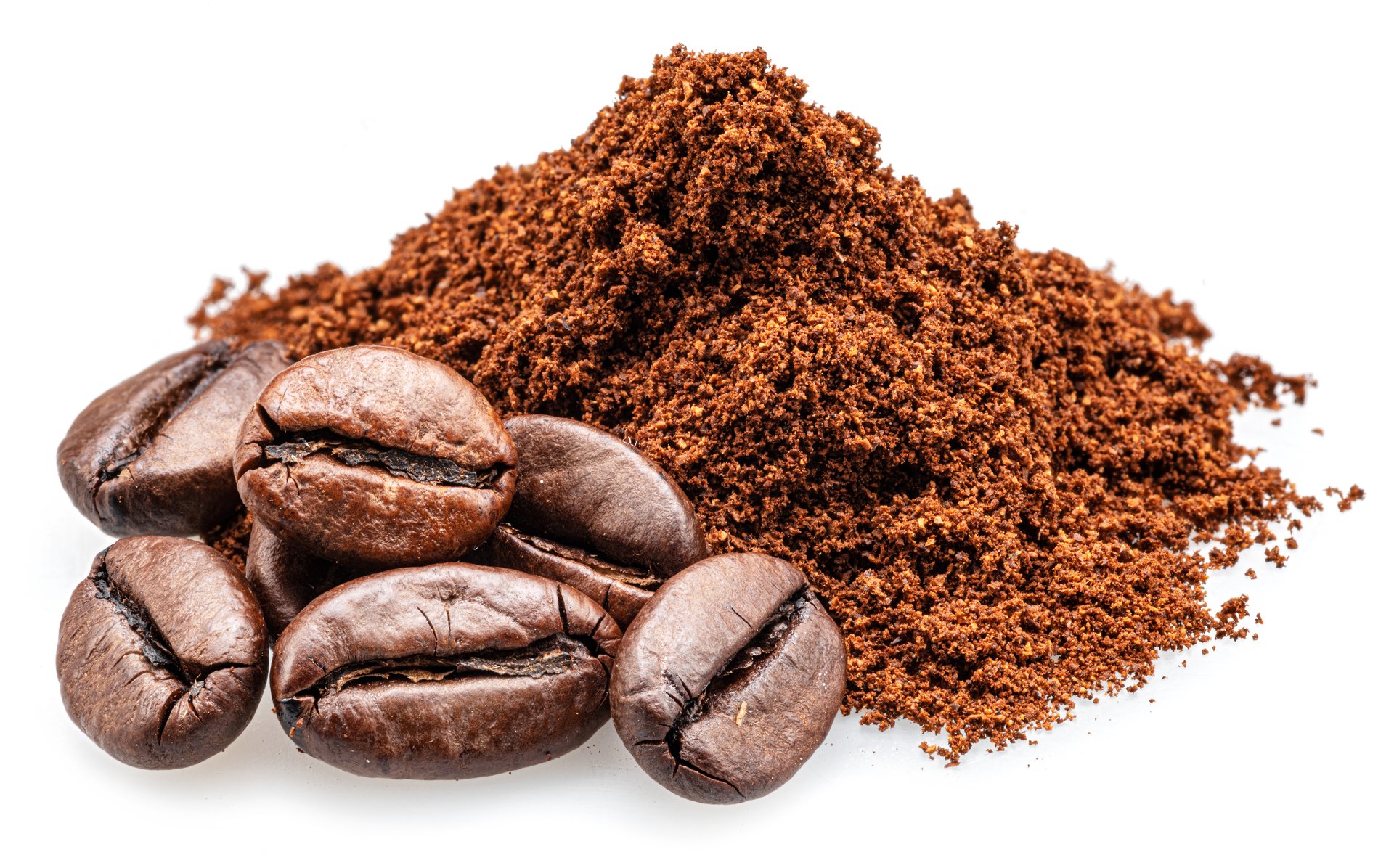 Heap of ground or crushed coffee beans and whole roasted coffee beans isolated on white background.