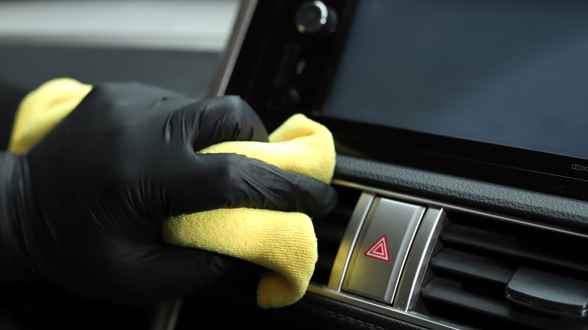Staff use microfiber cloth to clean cars at car care shop.