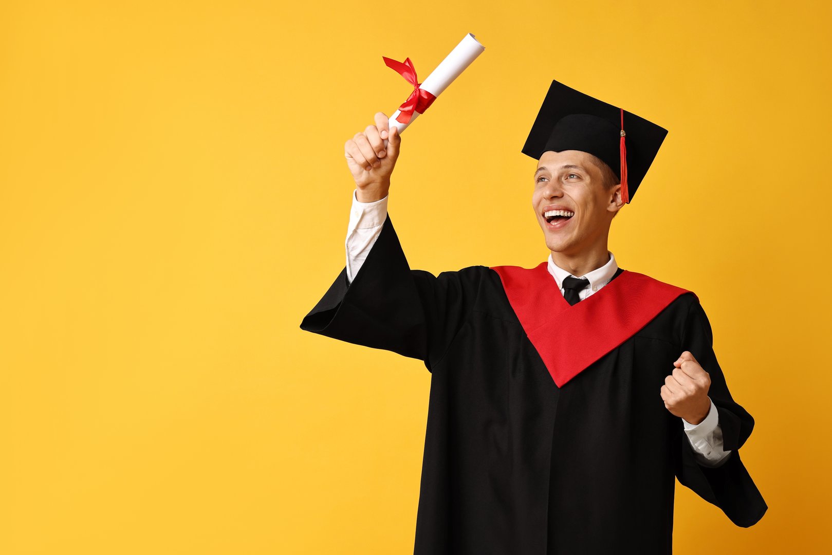 Happy student with diploma after graduation on orange background. Space for text