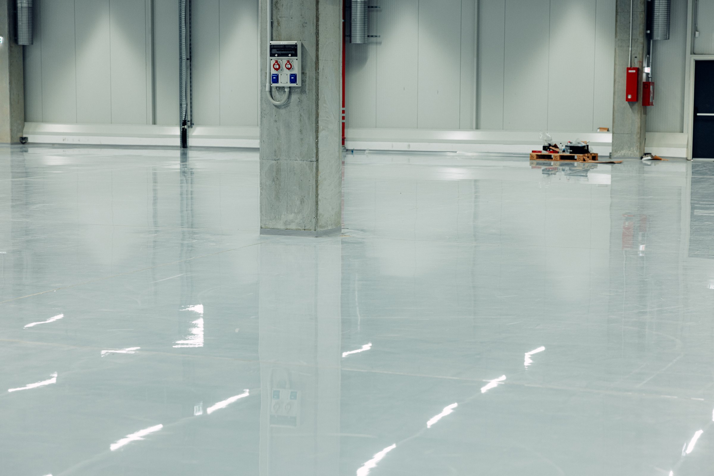 advanced epoxy coating system and industrial resin flooring ensuring a durable and visually appealing surface. Interior of a modern warehouse.