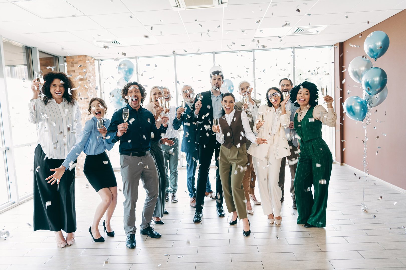 A group of professionals celebrate in an office with confetti and champagne, embodying teamwork, camaraderie, and workplace diversity, representing a festive moment in a modern business environment.