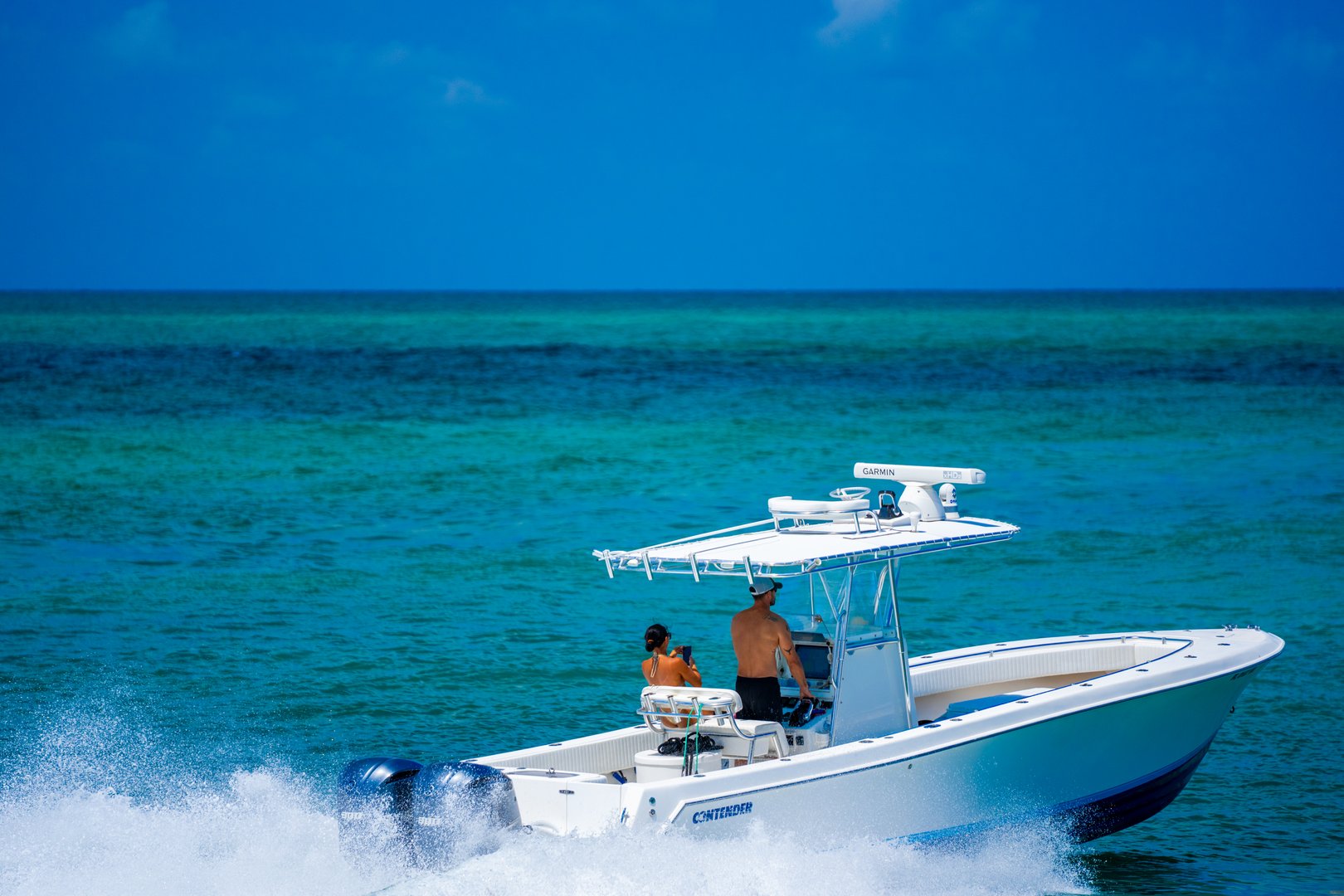 Miami Beach, FL, USA - May 25, 2025: Couple cruising on a Contender fishing boat in Miami