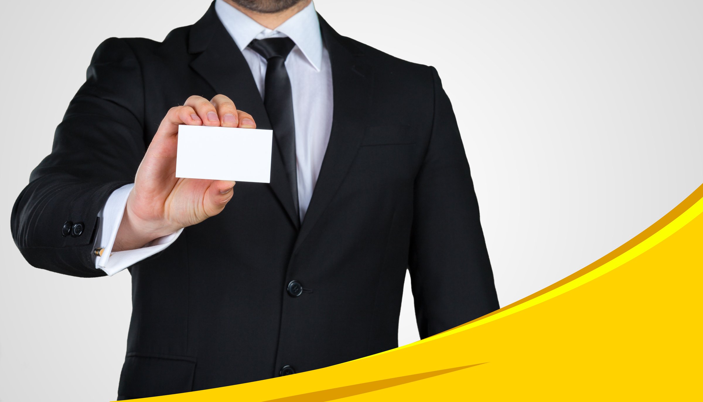 A man in a suit presents a blank business card, showcasing professionalism and readiness.