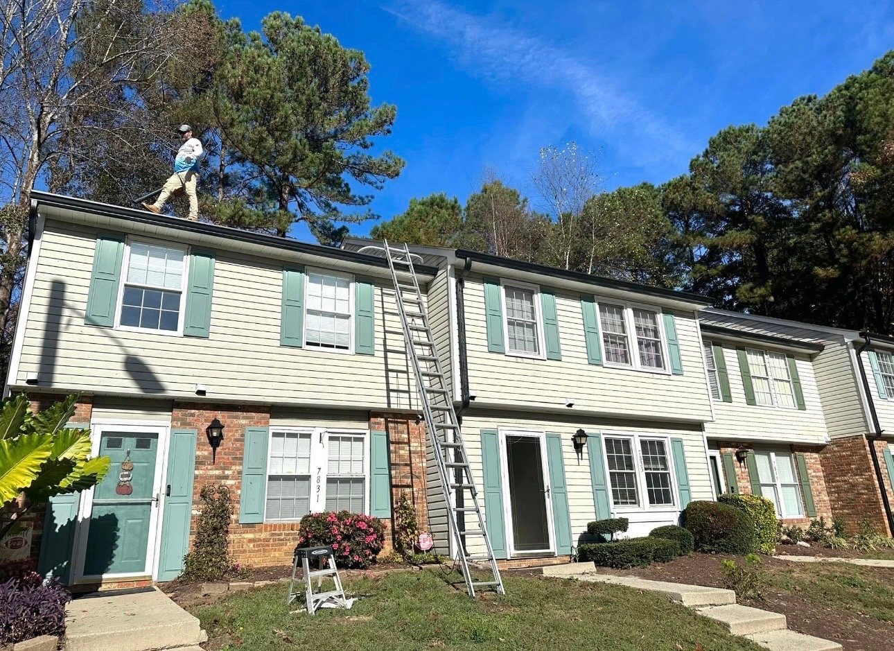 Worker pressure washing apartment rooftop