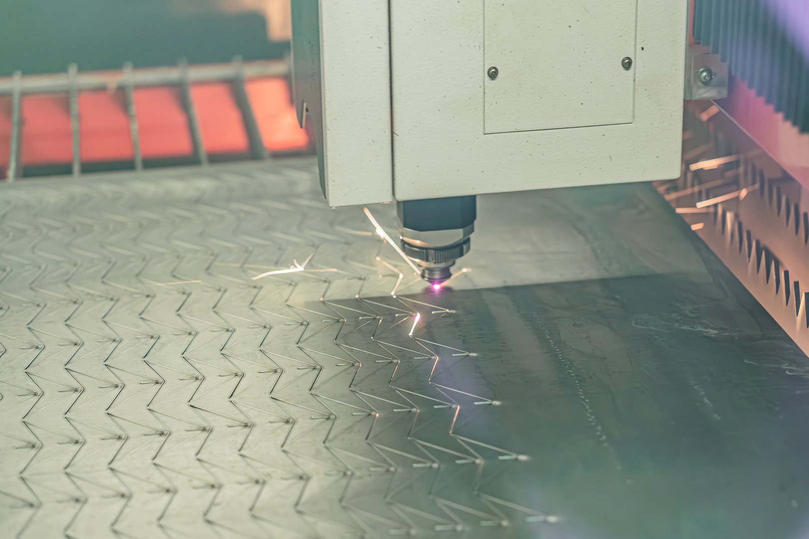 Close-up of industrial cutting process, metal sheet, machinery, cylindrical component, sparks, gray tones, technical style.