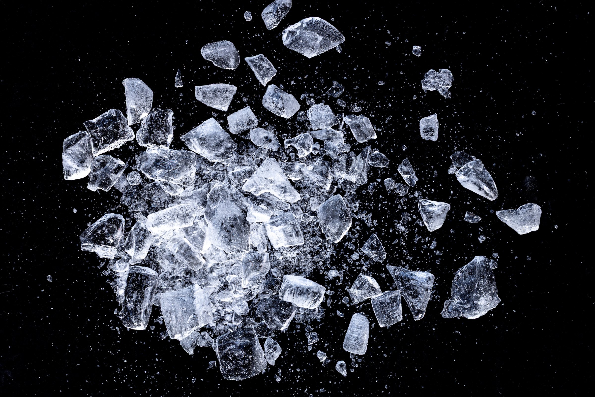 Ice shards crush on a black background. Chill backdrop.