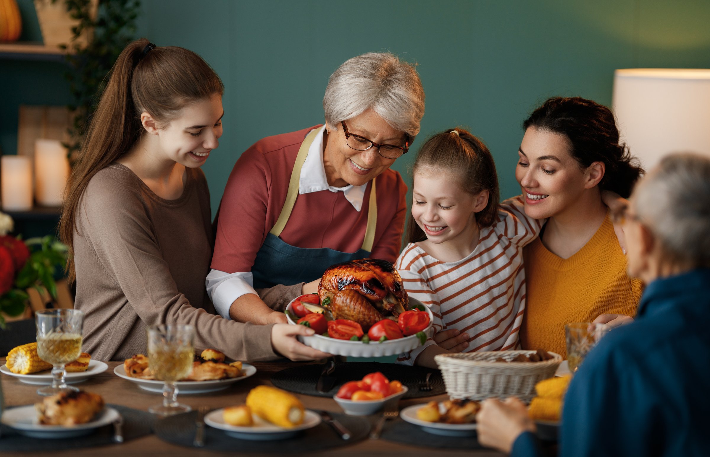 Happy Thanksgiving Day. Autumn feast. Family sitting at the table and celebrating holiday. Grandparents, mother and children. Traditional dinner.