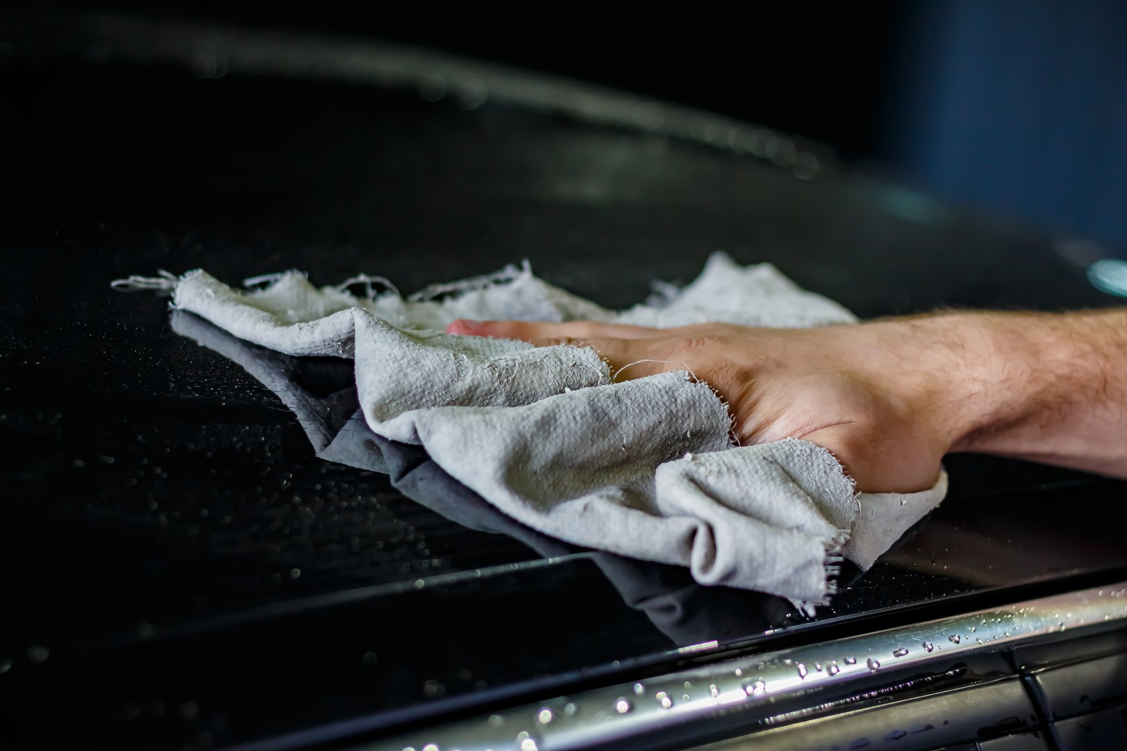 Hand polishing a car hood after washing