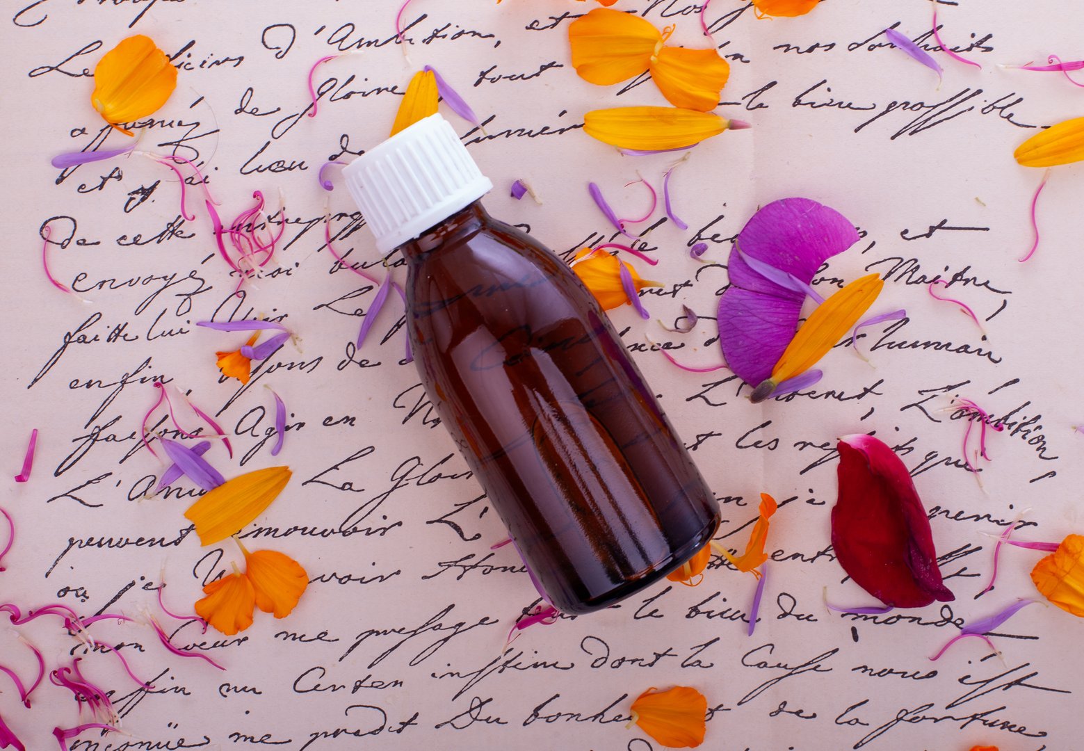 Botella de flores de Bach sobre notas manuscritas - terapia floral natural