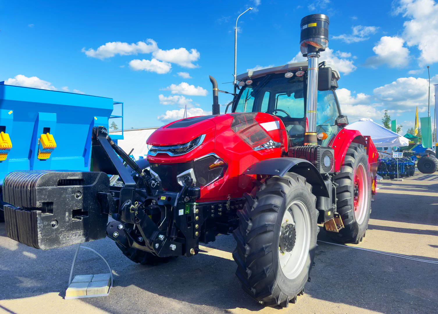 Farm tractor at the exhibition. Agricultural machinery. Red tractor for working in the field in agriculture. Agricultural tractor for farm industry. Agricultural machinery for farming.
