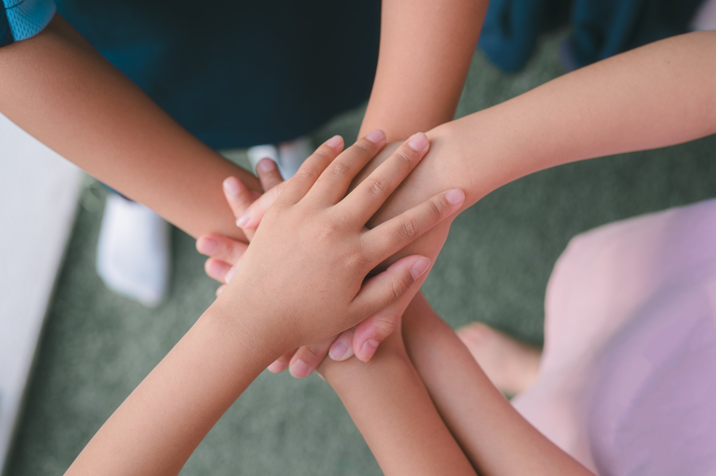 Team Huddle A friendly family joins their hands as a sign of joint success Stack of hands, below and children in nature for unity, support and friendship, girls stacking hands together in teamwork